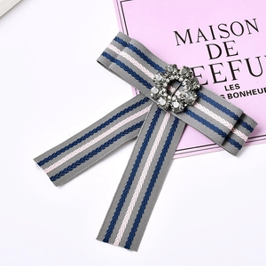Macro shot of striped bow brooch featuring a sparkling crystal ring and ribbed ribbon texture