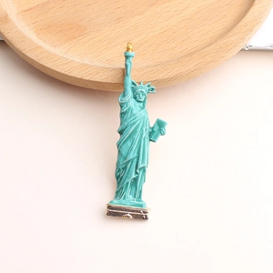 Detail of Statue of Liberty enamel brooch with turquoise finish and golden torch accents