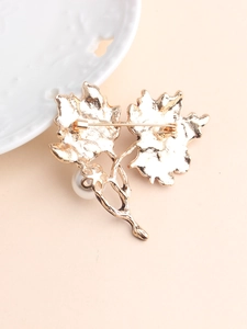 Detailed back view of gold maple leaf brooch with pin fastener and pearl detail