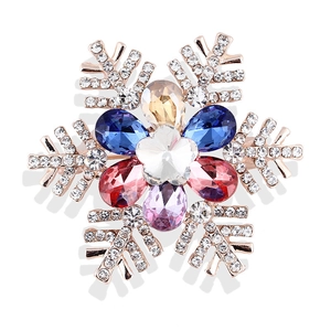 Primer plano de un broche de copo de nieve con cristales coloridos y chapado en oro rosa