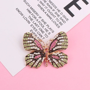 Détail macro de broche papillon avec strass verts et placage en or brillant