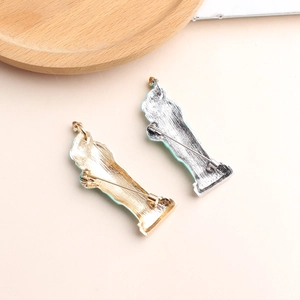 Gold and silver Statue of Liberty enamel brooches with blue finish on beige background