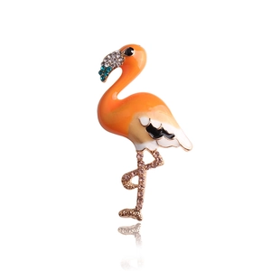 Detailed close-up of flamingo brooch with orange enamel and inlaid pink crystals