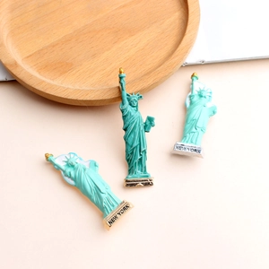 Detail view of Statue of Liberty brooches in green and teal with New York base