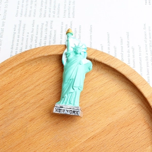 Close-up of mint green Statue of Liberty souvenir on wooden tray with New York text