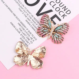 Broche papillon dorée avec strass roses et bleus vue de face et de l'arrière de l'objet