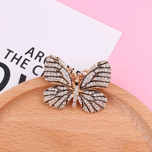 Gros plan d'une broche papillon en alliage doré ornée de cristaux brillants