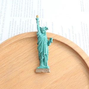 Detail view of Statue of Liberty brooch with green enamel and gold metal base