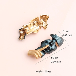 Surrealist mask face brooch with gold hand and matte black finish, 5.3x2.1cm dimension