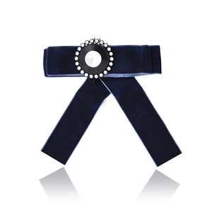 Detail of elegant navy velvet bow brooch with sparkling crystal and rhinestone center