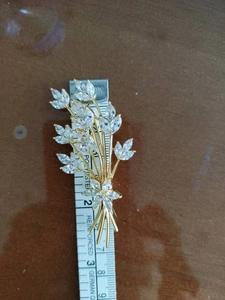 Detail view of crystal wheat ear brooch in gold alloy with measuring ruler scale