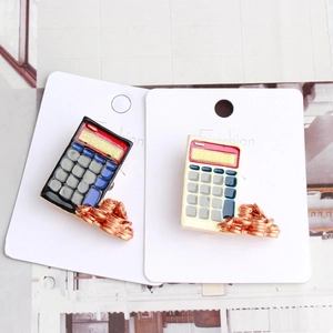 Close-up of calculator enamel brooches with rose gold coin base on display cards