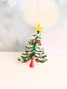 Détail macro d'une broche sapin de Noël en émail vert avec strass multicolores