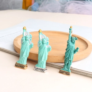 Detailed close-up of Statue of Liberty enamel brooches with New York base engraving