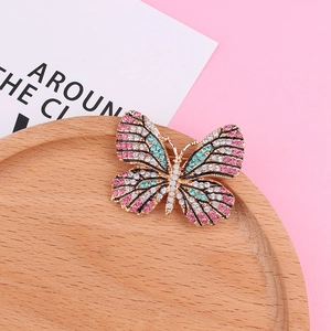 Vue détaillée d'une élégante broche papillon avec strass roses et bleus sur bois