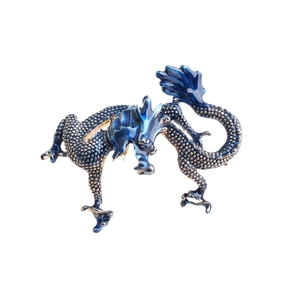 Broche dragon exquise en émail bleu avec écailles dorées sur fond blanc neutre