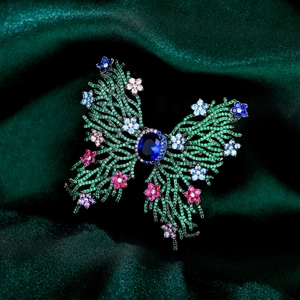 Macro shot of butterfly brooch with green pavé zircon and vibrant colorful gemstones