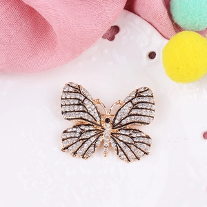 Exquise broche papillon plaquée or avec strass étincelants et détails en émail noir