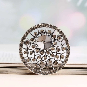 Broche baroque évidée ornée d'un grand cristal gris et de strass sur monture argentée