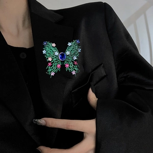 Luxury green butterfly brooch with zircon flowers on a black suit jacket lapel