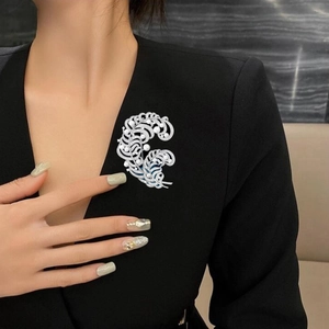 Elegant silver feather brooch with freshwater pearls and zircon on a black blazer