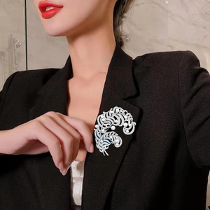 Elegant silver feather brooch with freshwater pearls and zircons worn on a black blazer