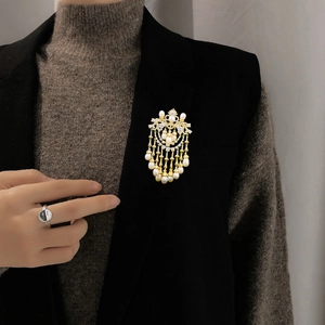 Detailed view of luxury zircon tassel brooch with pearls on a black suit blazer lapel