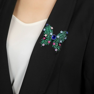 Luxury multi-color crystal butterfly brooch with blue centerpiece on a black suit blazer