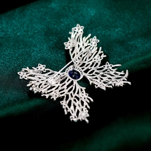 Macro shot of silver butterfly brooch back showing the pin mechanism and blue gemstone detail