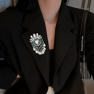 Elegant silver tassel brooch with pearls and zircons on a black suit lapel