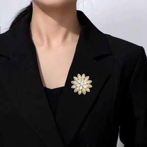 Dettaglio della spilla a fiore di loto con zirconi lucenti su un bavero nero