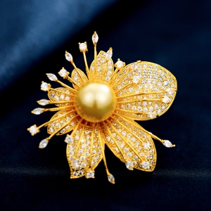 Makro-Detail einer Blumenbrosche mit Zirkonia-Mikropavé und goldener Perle