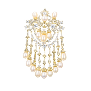 Detail of luxury gold brooch with zircon crystals and cascading pearl tassels on white base