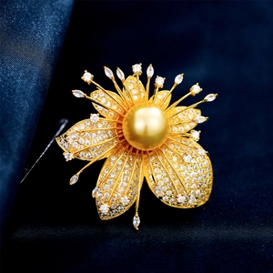 Makro-Detail der Blattblumenbrosche mit großer goldener Perle und Pavé-Kristallen