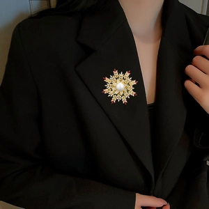 Detailed view of luxury snowflake brooch with white pearl and sparkling zircons on a blazer
