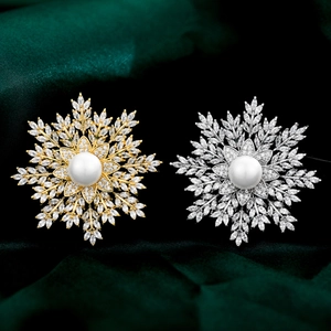 Macro detail of snowflake brooches with cubic zirconia and pearls on silk