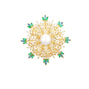 Detailed macro view of a gold snowflake brooch with white pearl and colorful crystals