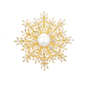 Detail of snowflake brooch with gold setting, central pearl, and shimmering zircon pavé