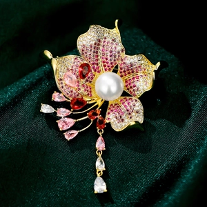 Macro shot of colorful flower brooch with vibrant crystals and a large central white pearl