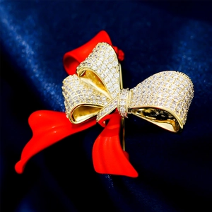 Close-up of a luxury red enamel bow brooch with gold-plated micro-pave zircon crystals