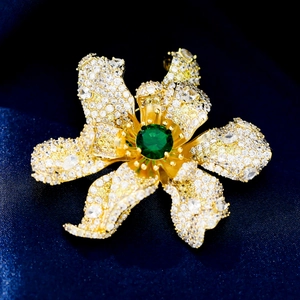 Detailed close-up of a luxury flower brooch with emerald green stone and zircon petals