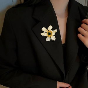 Elegant 3D flower brooch with green gemstone and zircon pavé on a black blazer