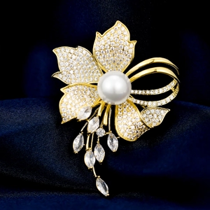 Macro detail of floral zircon brooch with white pearl and marquise-cut pendants
