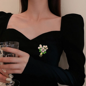 Elegante spilla a bouquet di fiori con zirconi e smalto su un abito nero