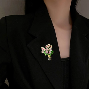 Spilla a bouquet di fiori con margherite bianche e zirconi rosa su giacca nera