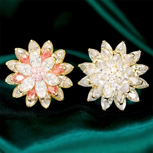 Detailed macro view of sparkling zircon lotus flower brooches on luxury green velvet