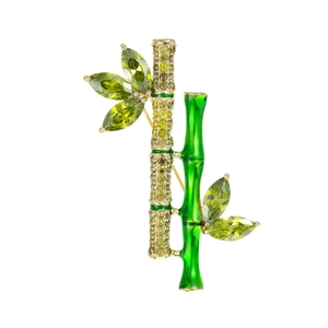 Elegant bamboo brooch with green enamel and yellow zircon stones on a white background