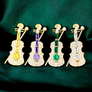 Close-up of violin brooches with micro-pave crystals and colorful gems on silk
