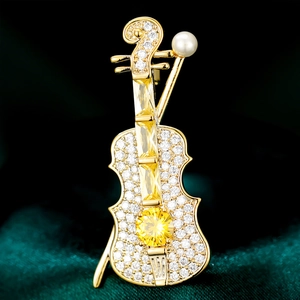 Elegant gold violin brooch with micro-paved zircons and yellow gemstone on velvet