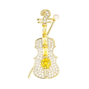 Macro detail of violin brooch featuring micro-set zircons and yellow gemstones on gold base